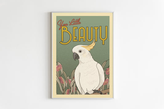 An illustration of a Sulfur Crested Cockatoo with text above it saying "YOU LITTLE BEAUTY" The illustration is on a blue background